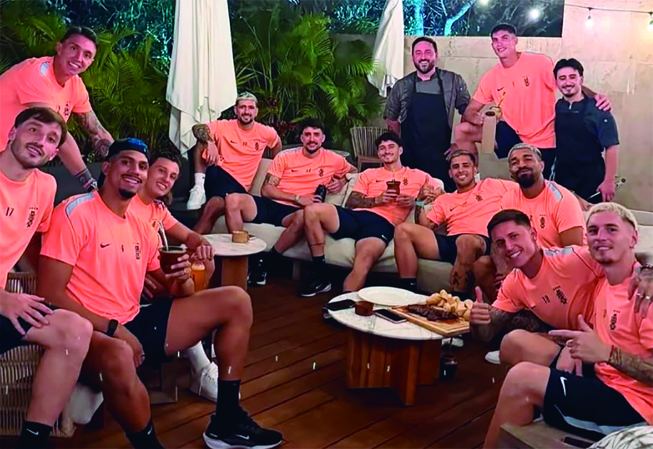 Los futbolistas compartiendo un asado con el asador Aldo Cauteruccio, lo que refleja que la unidad del grupo ha mejorado.