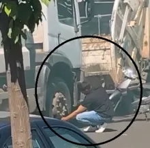  Funcionarios pretendiendo desinflar el neumático de uno de los camiones para evitar que salgan a cumplir el servicio.