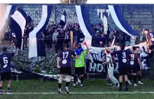 Jugadores, técnicos y allegados, con la banda del Sala de fondo.